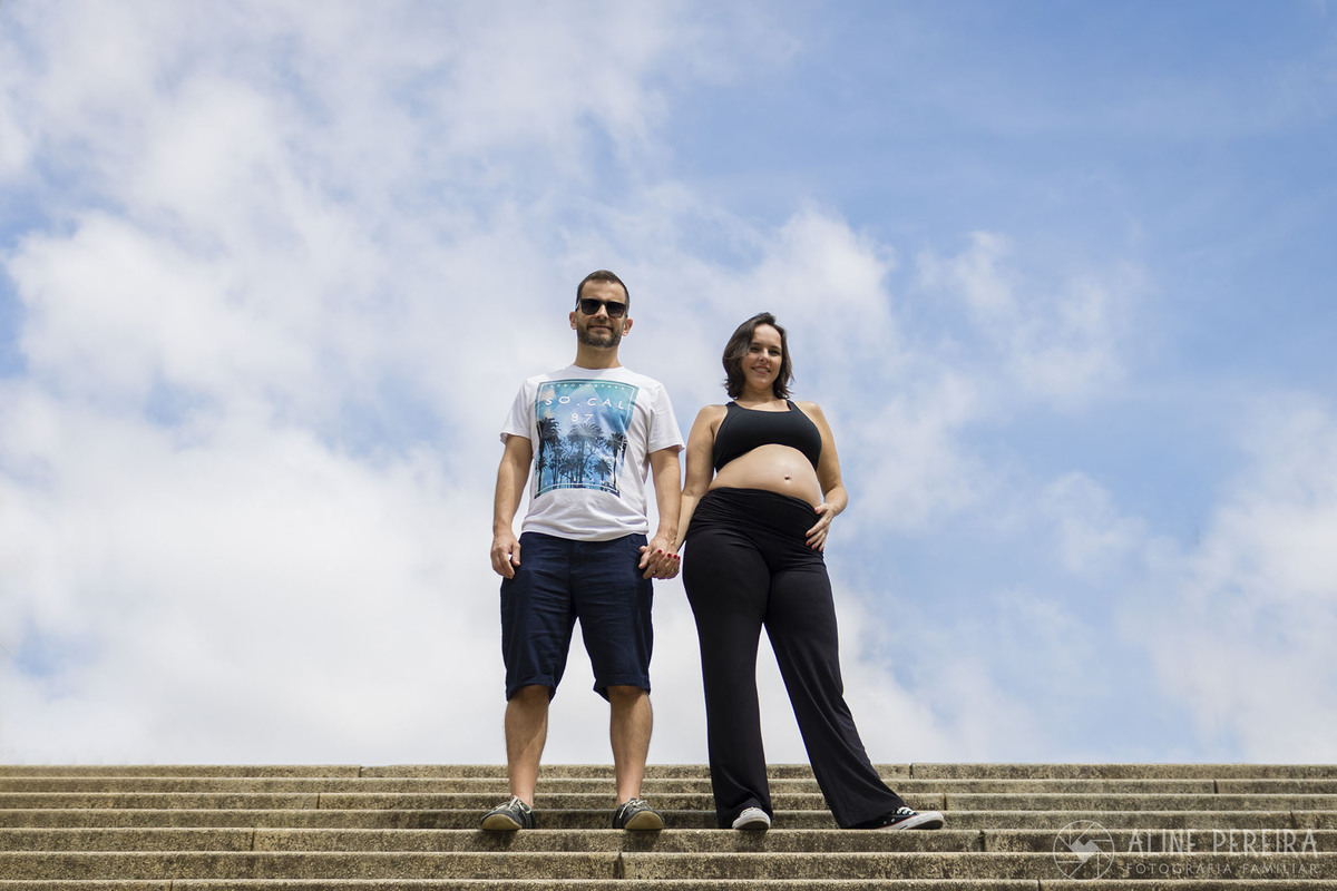 Casal em pé na escada com o céu azul de fundo