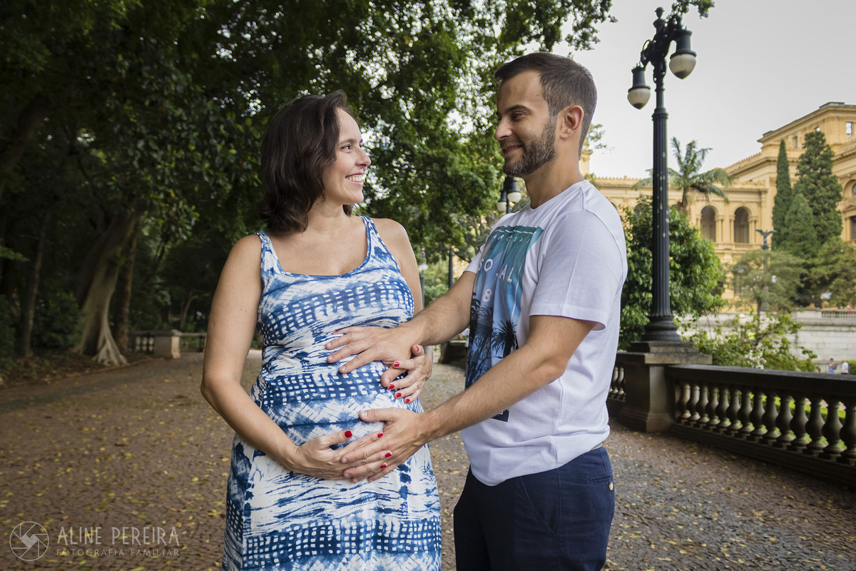 casal com as mãos na barriga de grávida em frente ao Museu do Ipiranga