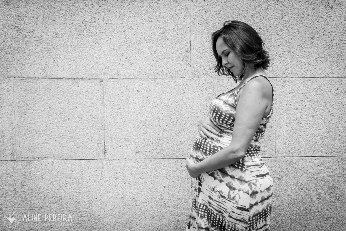 gravida de perfil posando com as mãos na barriga