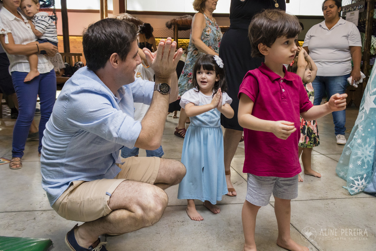 Pai ensinando a filha a dançar baby shark na festa de aniversário