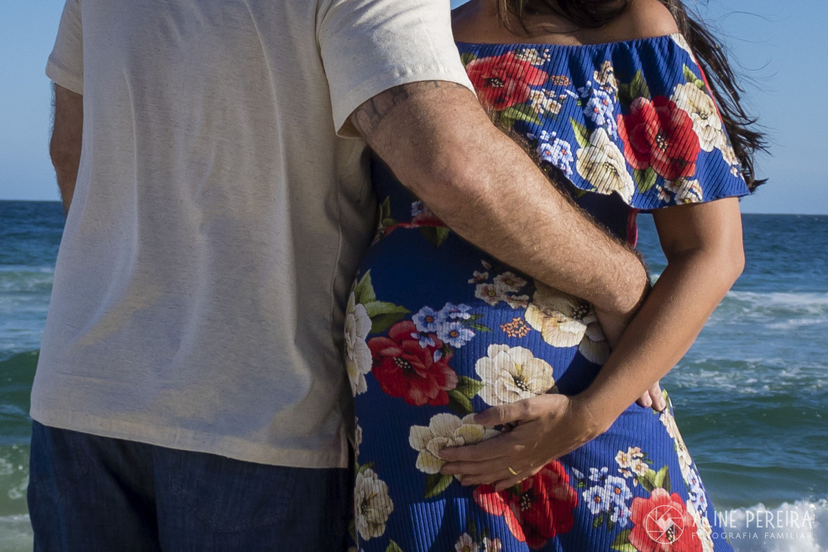 foto de abraço entre homem e mulher grávida na praia