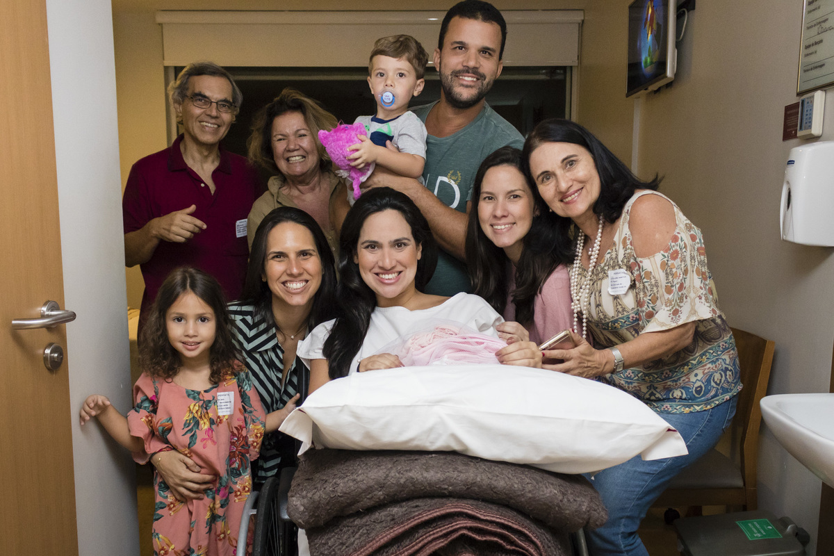 família se despedindo da mulher grávida que está indo para a sala de cirurgia