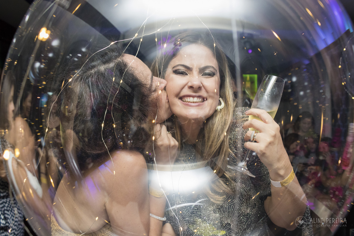 aniversariante ganhando um beijo da amiga em sua festa de 40 anos no Longe Ki