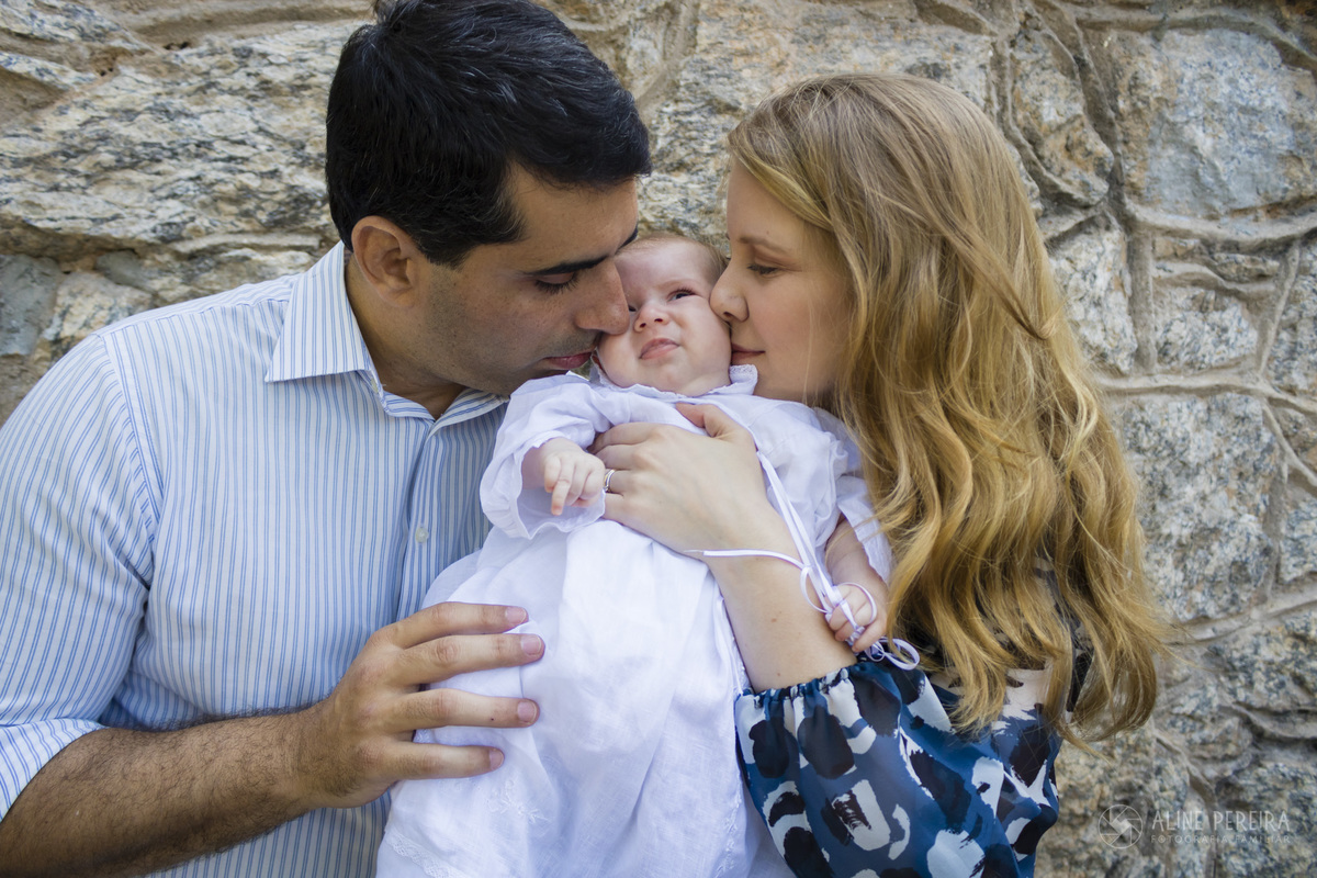 pais dando beijinho no bebê após o batizado