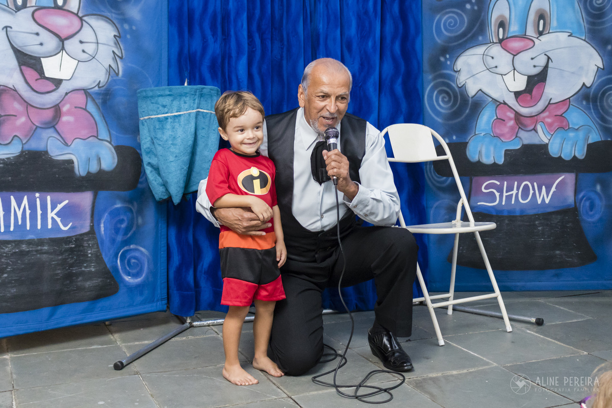 aniversariante ao lado do mágico Almik na festa de aniversário