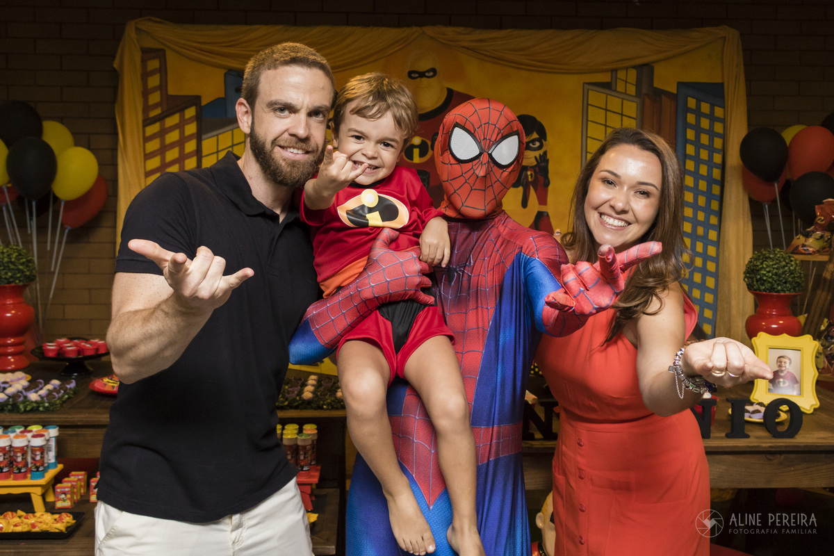 familia com o personagem vivo do homem-aranha em frente a mesa do aniversário decorada