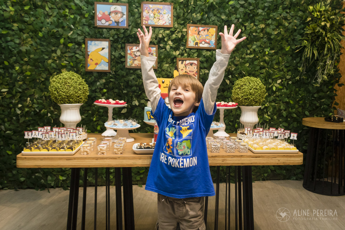 aniversariante na mesa do bolo decorada com o tema pokemon