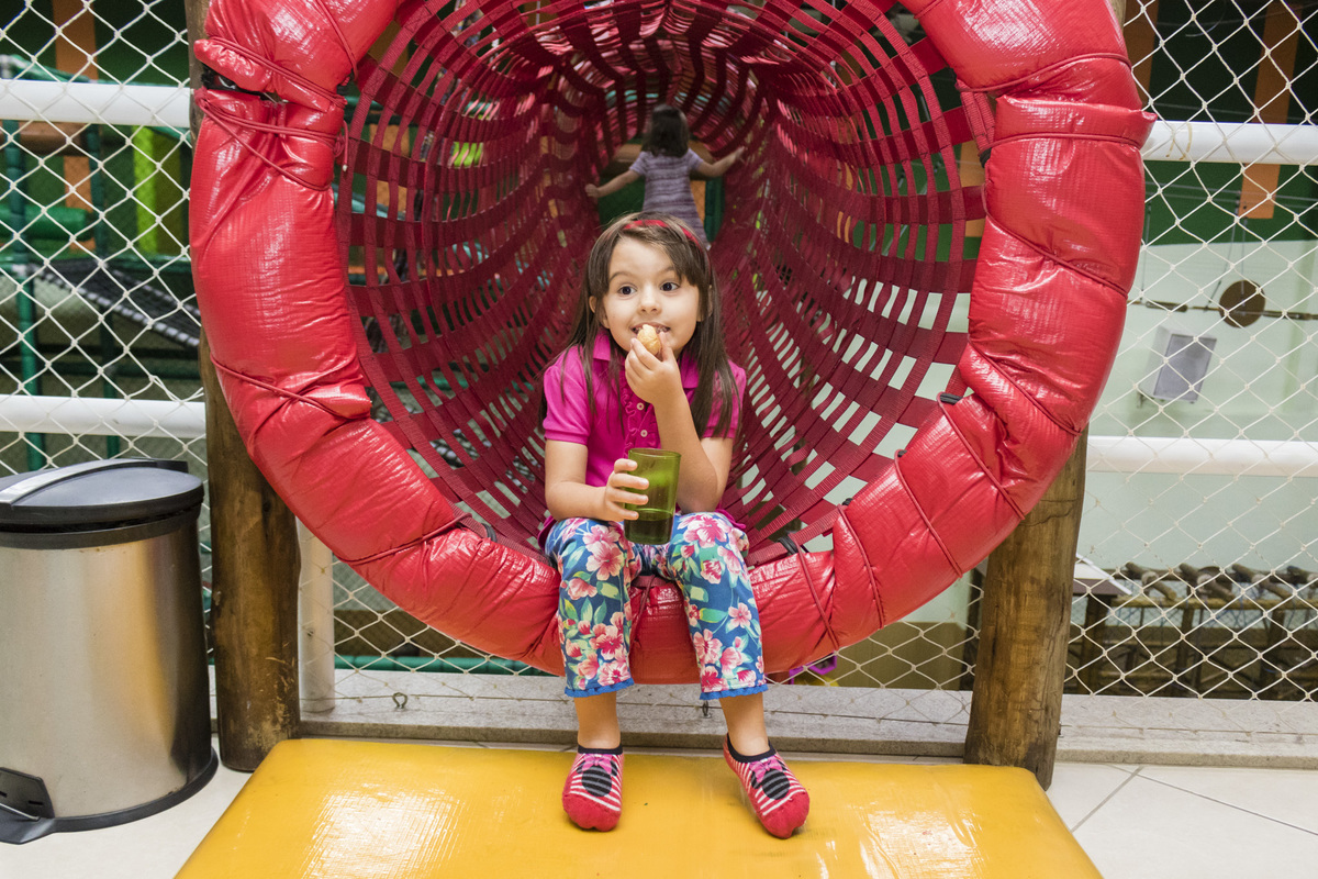 menina sentada na entrada do tunel. brinquedo da casa de festas Animania