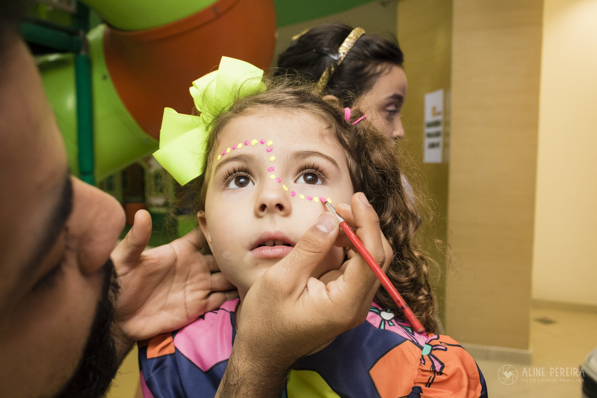 menina tendo o rosto pintado na casa de festas Animania
