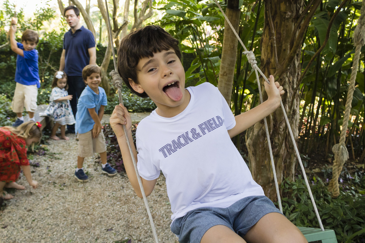 menino se divertindo no balanço na festa de aniversário ao ar livre