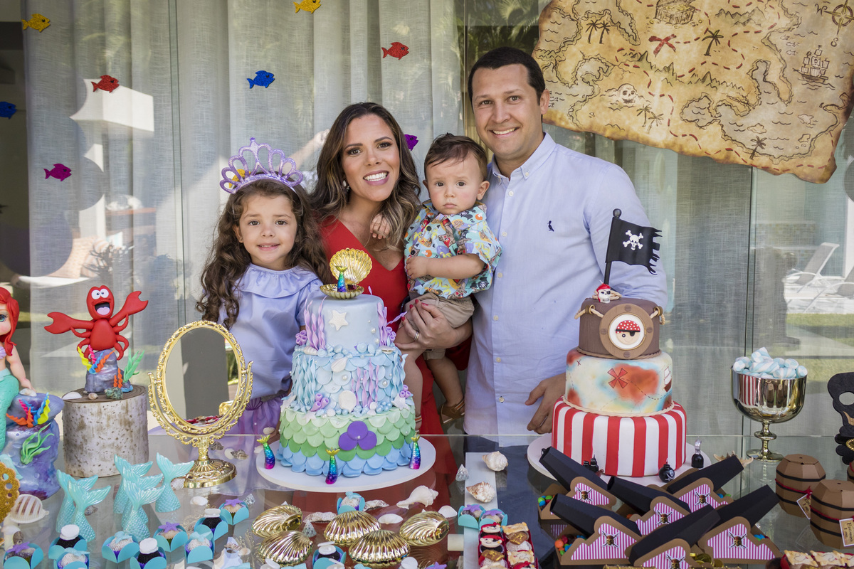 familia reunida na mesa do bolo decorada com tema sereias e piratas