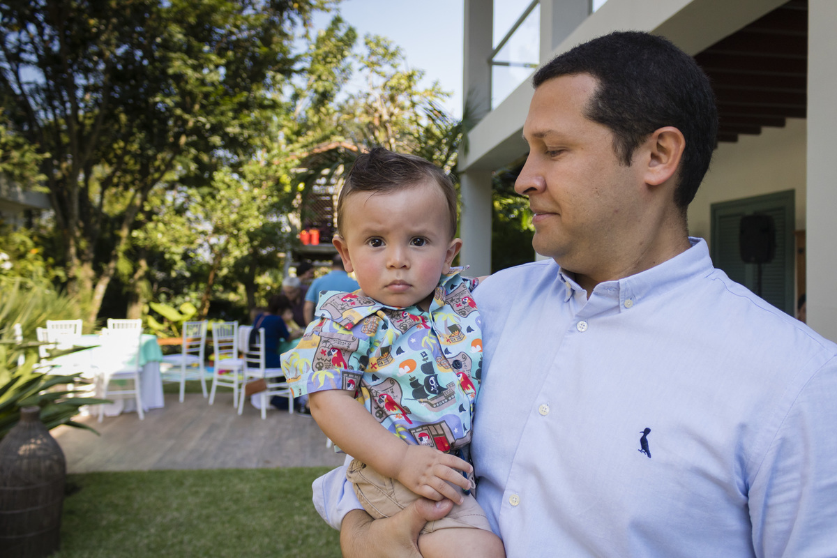 aniversariante no colo do pai na festa de aniversario ao ar livre