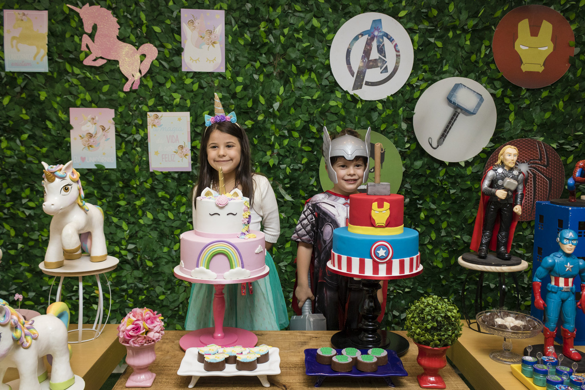 aniversariantes na mesa do bolo com os temas unicornio e herois na casa de festas animania
