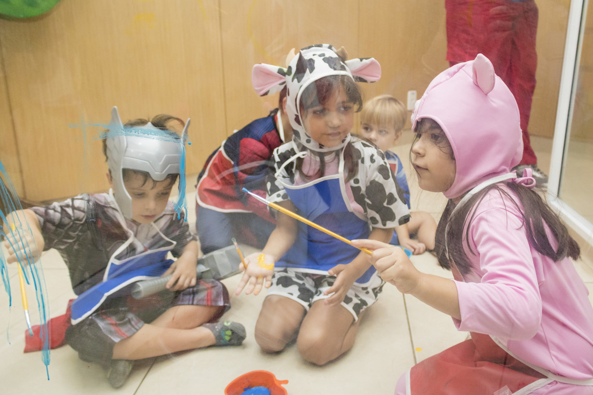 crianças fantasiadas brincando de pintar