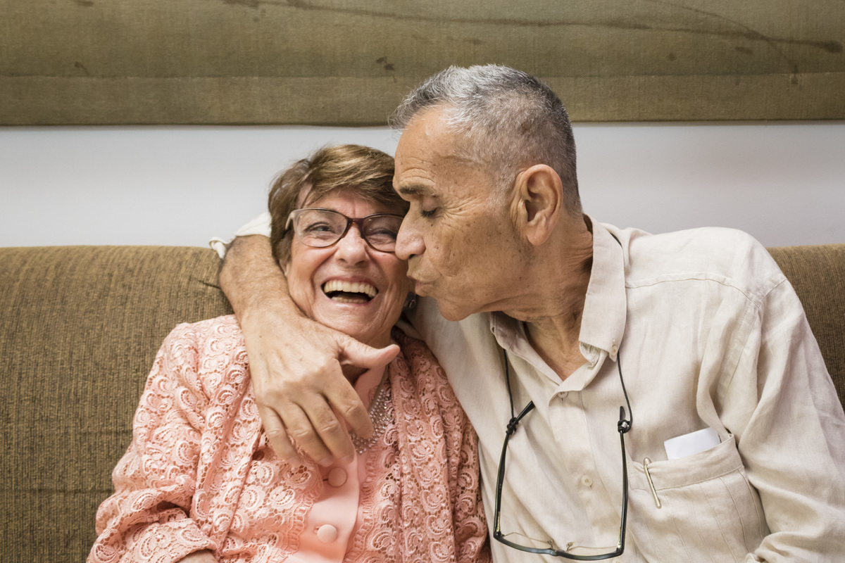 Casal dando um beijo na comemoração de sua bodas de ouro
