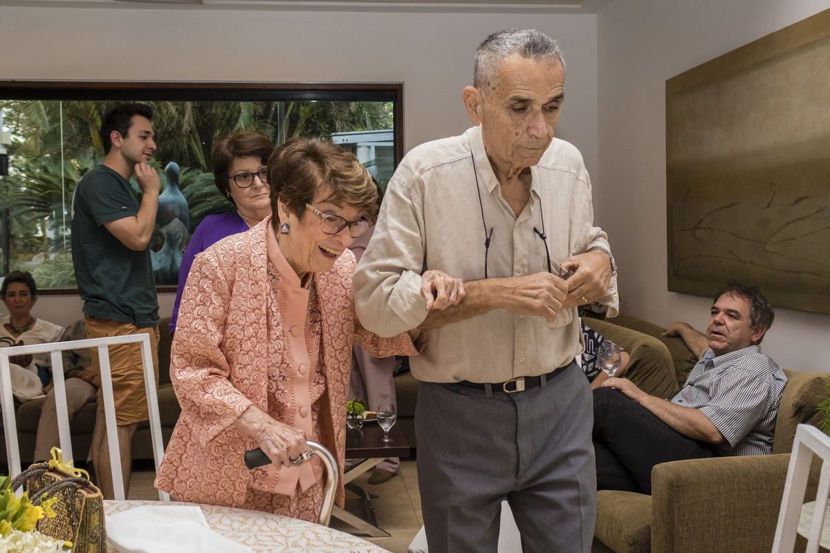 homem idoso de braço dado com a esposa idosa na festa de bodas de ouro