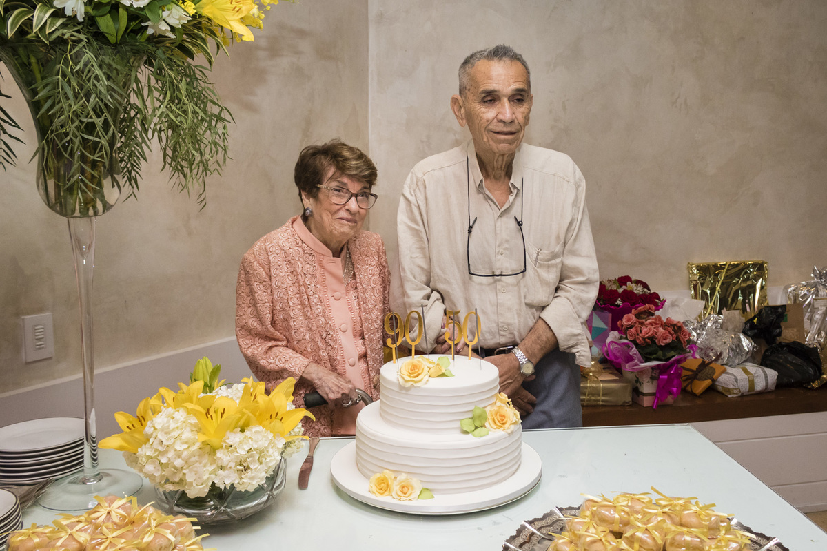 casal idoso na mesa do bolo para a comemoração das bodas de ouro