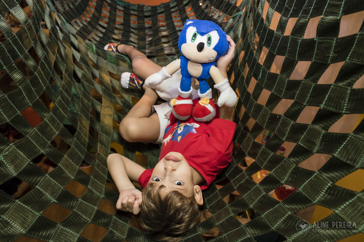 Menino brincando na casa de festas Upkids com o seu boneco de pelúcia do sonic