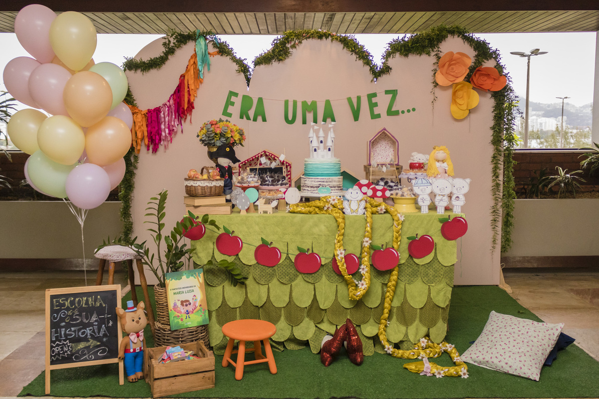 mesa do bolo decorada com o tema contos infantis