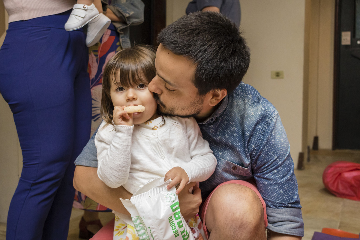 pai beijando a filha na festa de aniversário