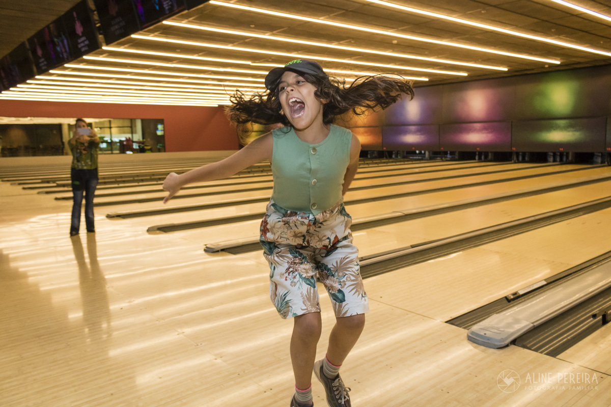 menina pulando depois de fazer um strike no Barra Bowling no BarraShopping