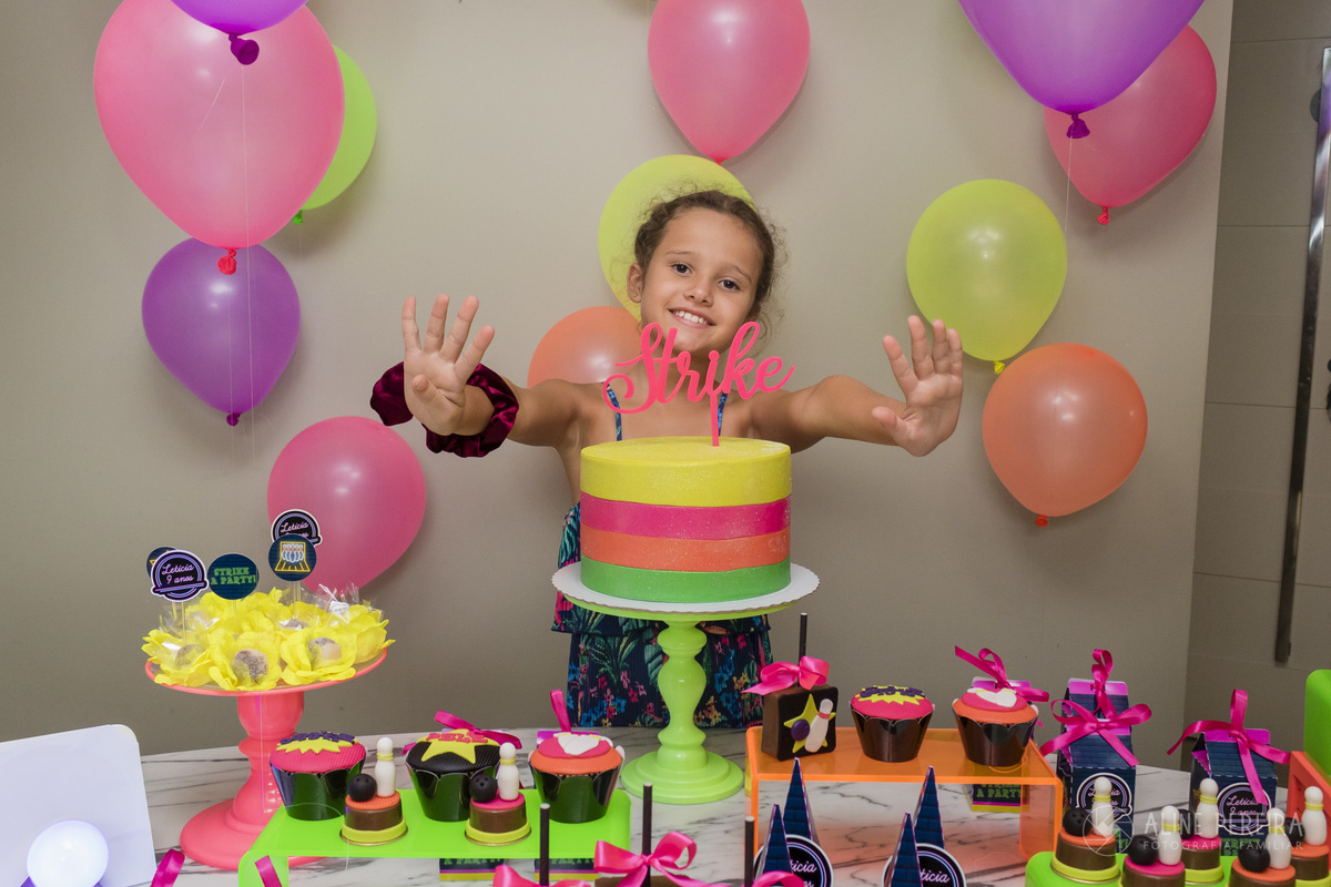 aniversariante na mesa do bolo decorada com o tema boliche