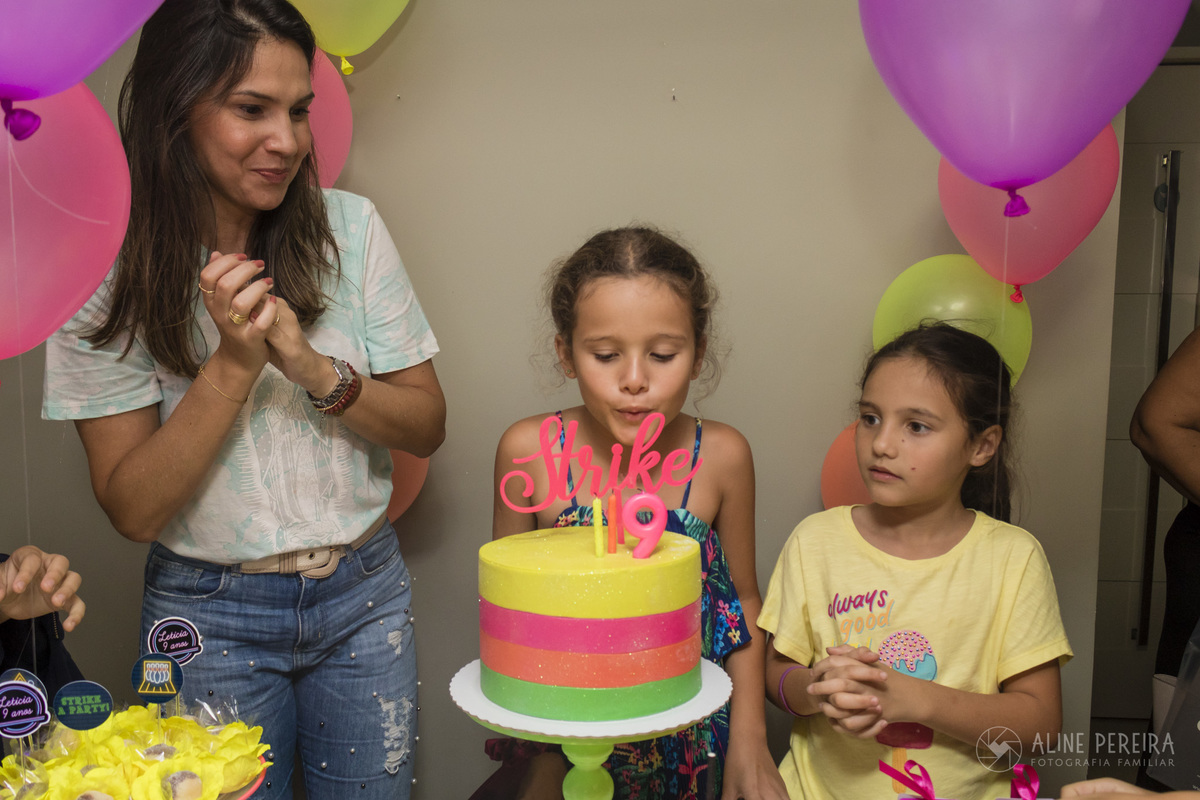 menina apagando a velhinha do bolo decorado com o tema boliche