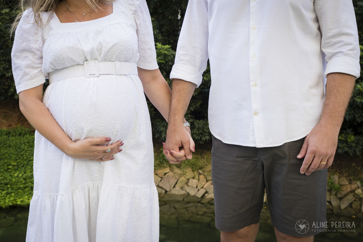 mulher gravida segurando a barriga de mãos dadas com o marido