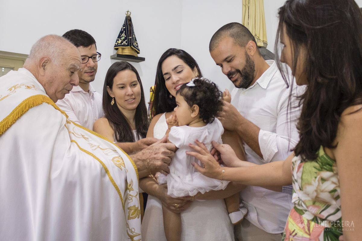 menina sendo abençoada pela familia no batizado