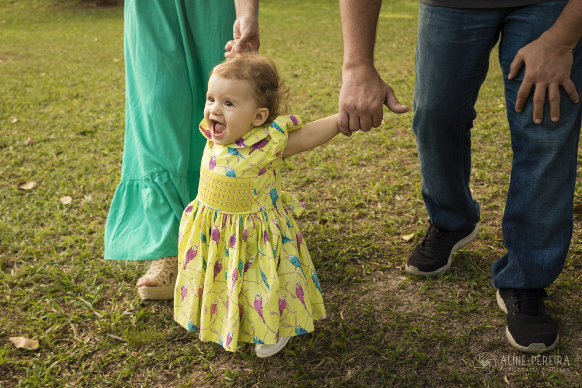 criança feliz segurando a mão da mãe e do pai