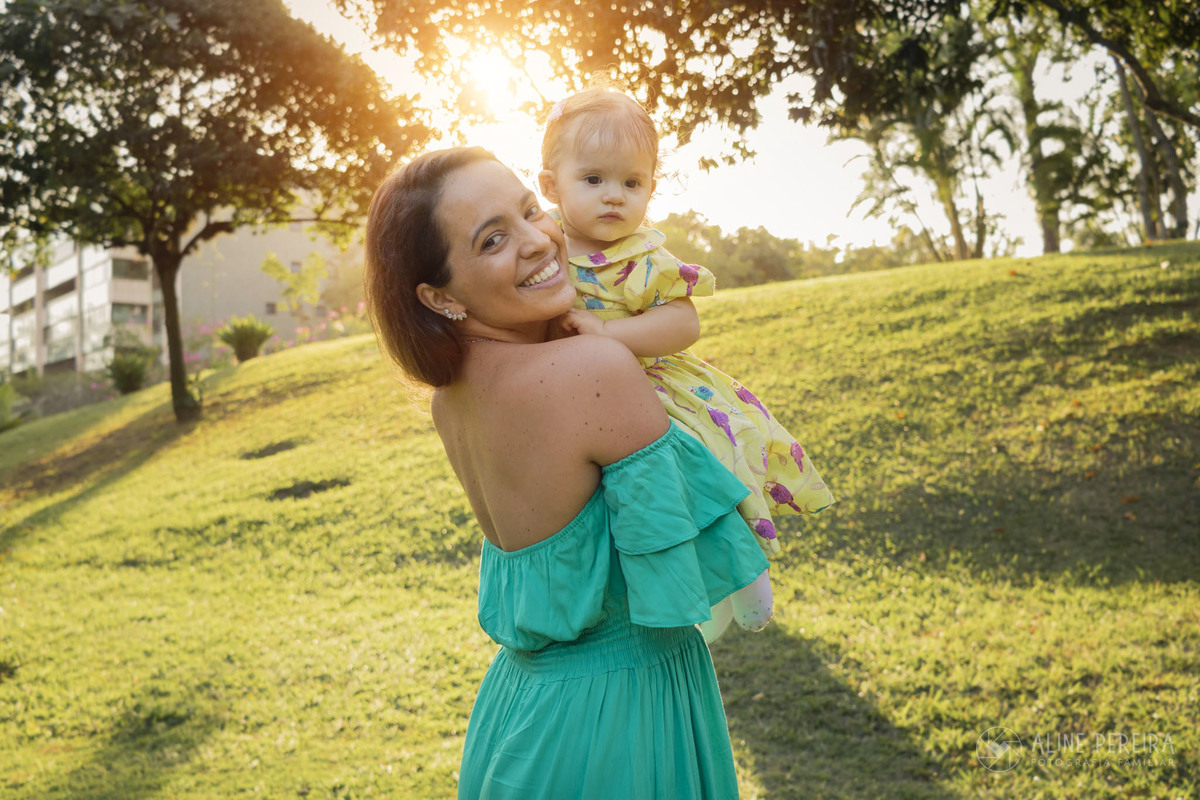mãe e filha no parque com o sol ao fundo 