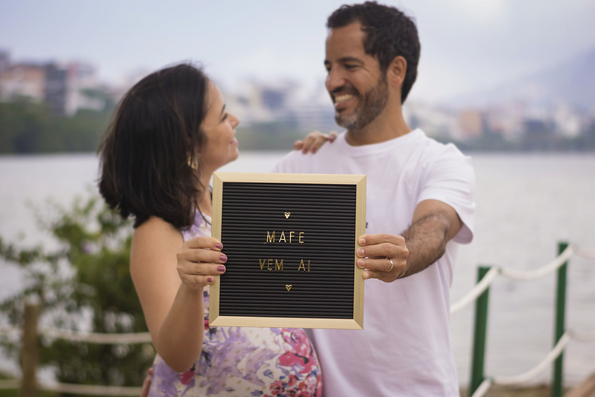 casal segurando um quadrinho a espera do neném que está por vir