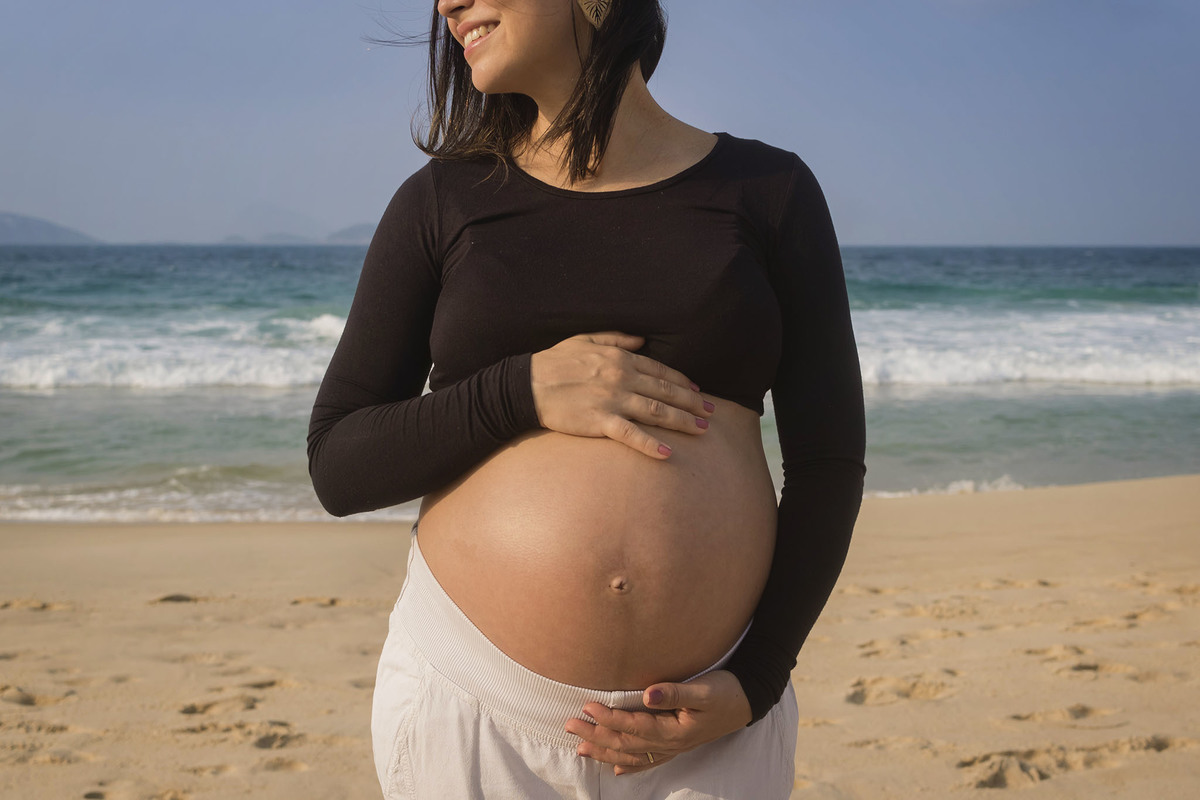 mulher gravida com a barriga de fora na praia de ipanema