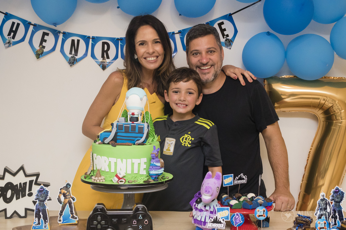 família na mesa do bolo com o tema fortnite
