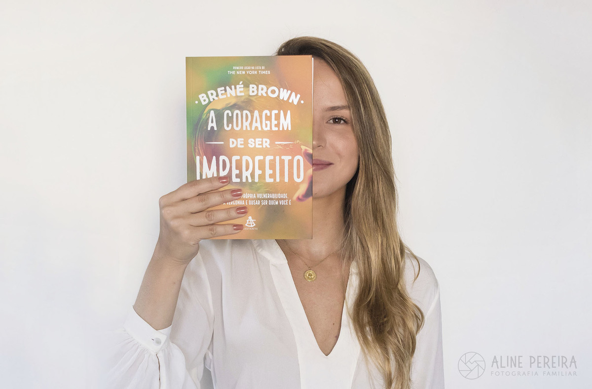 mulher segurando o livro A coragem de ser imperfeito