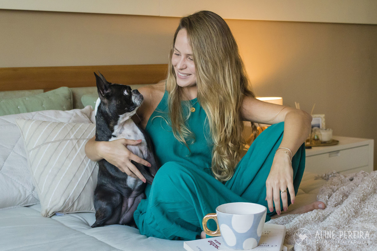 mulher na sua cama com o seu cachorro da raça pug