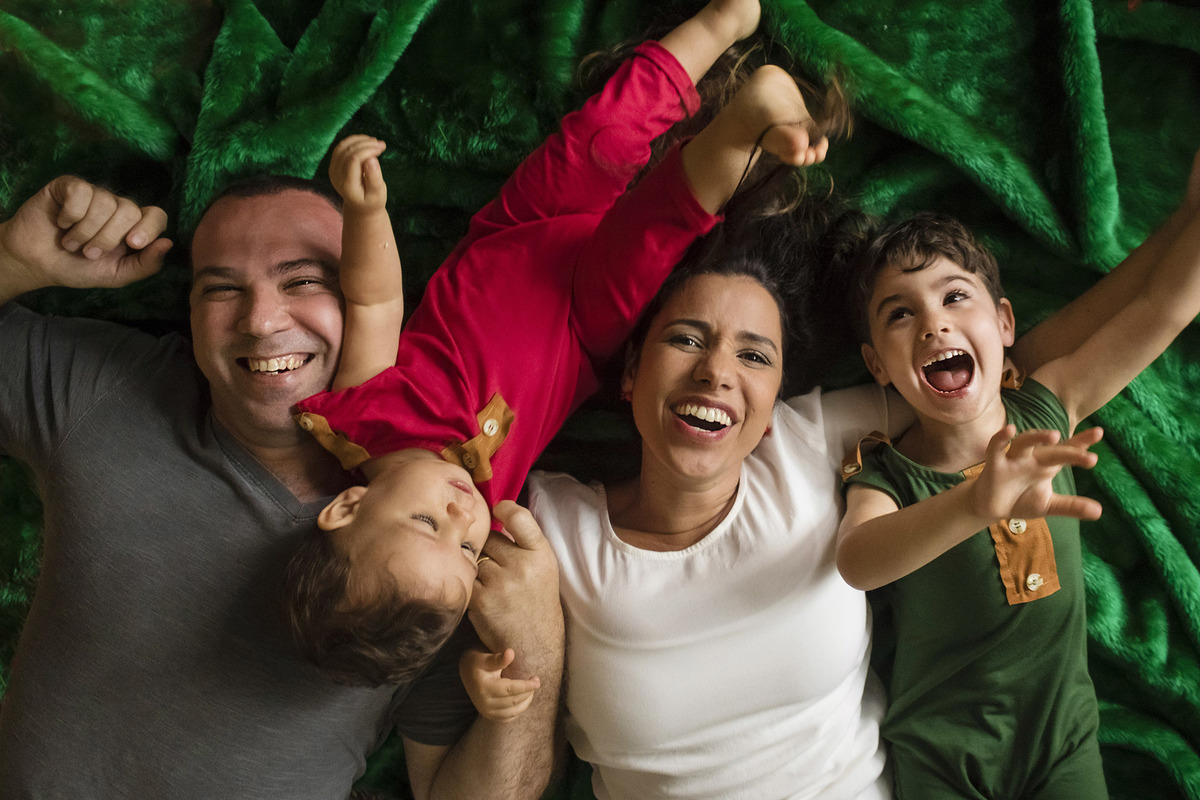 família feliz deitada em tapete verde