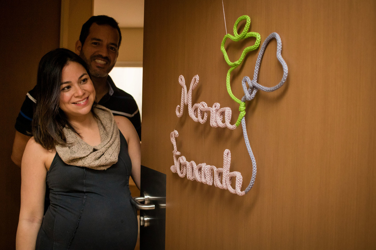 Pais na porta do quarto da maternidade com o enfeite na porta