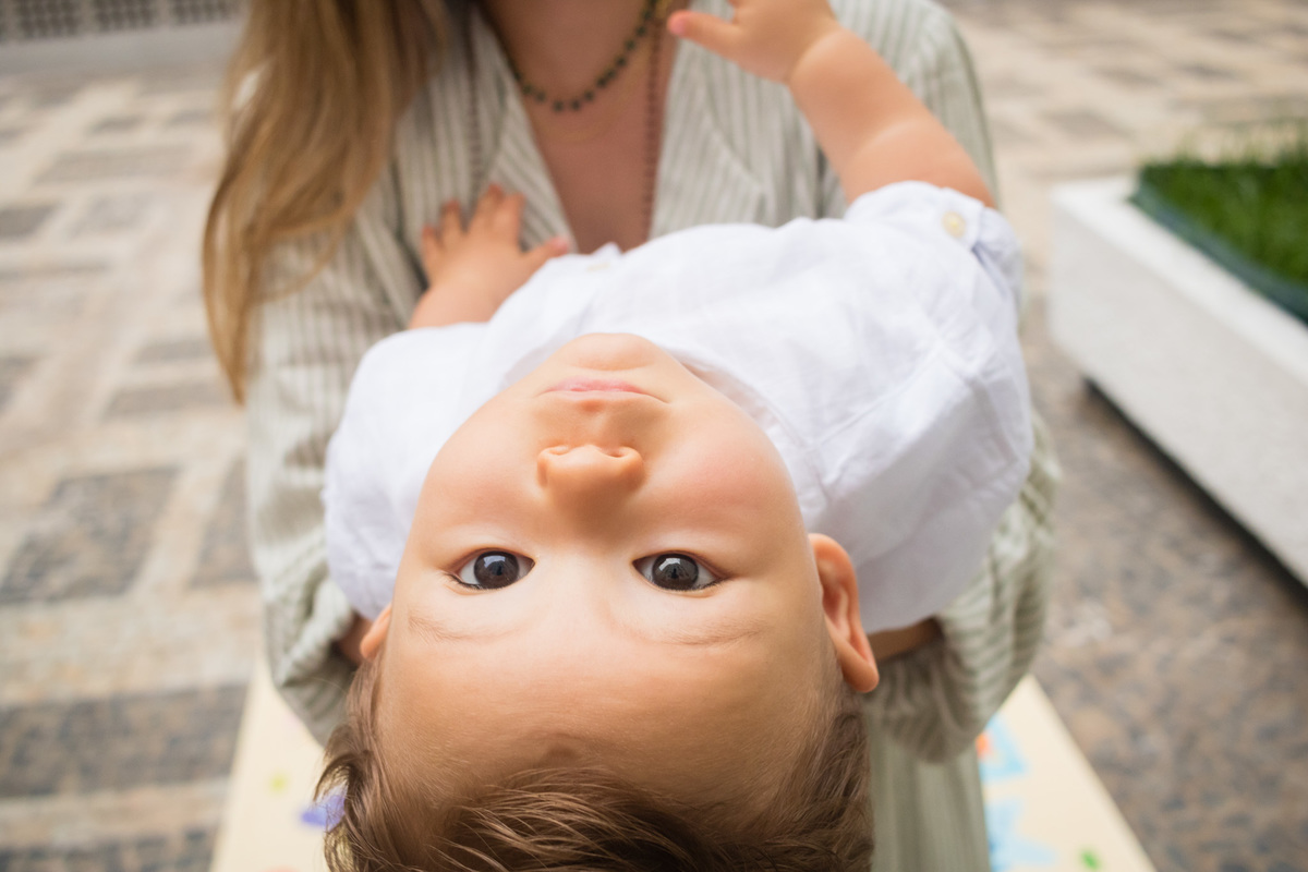 criança pequena de ponta cabeça olhando para a foto