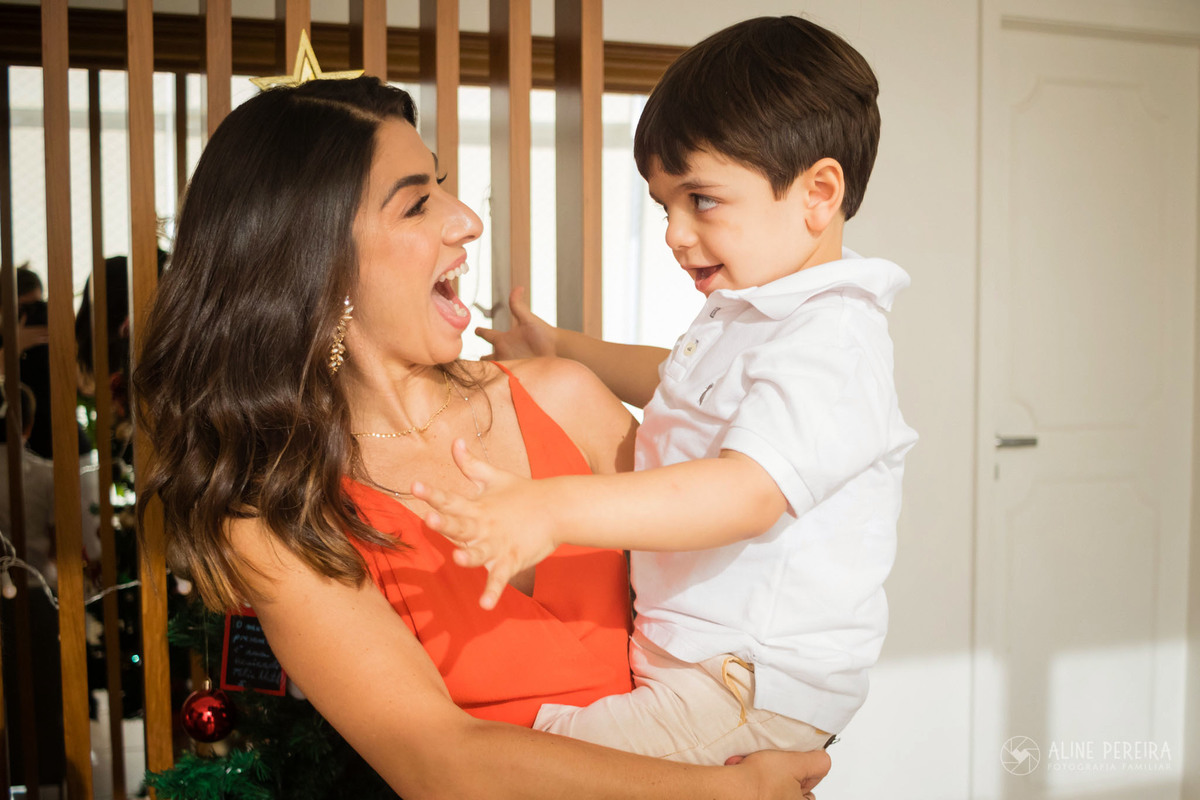 mãe e filho sorrindo um para o outro natal
