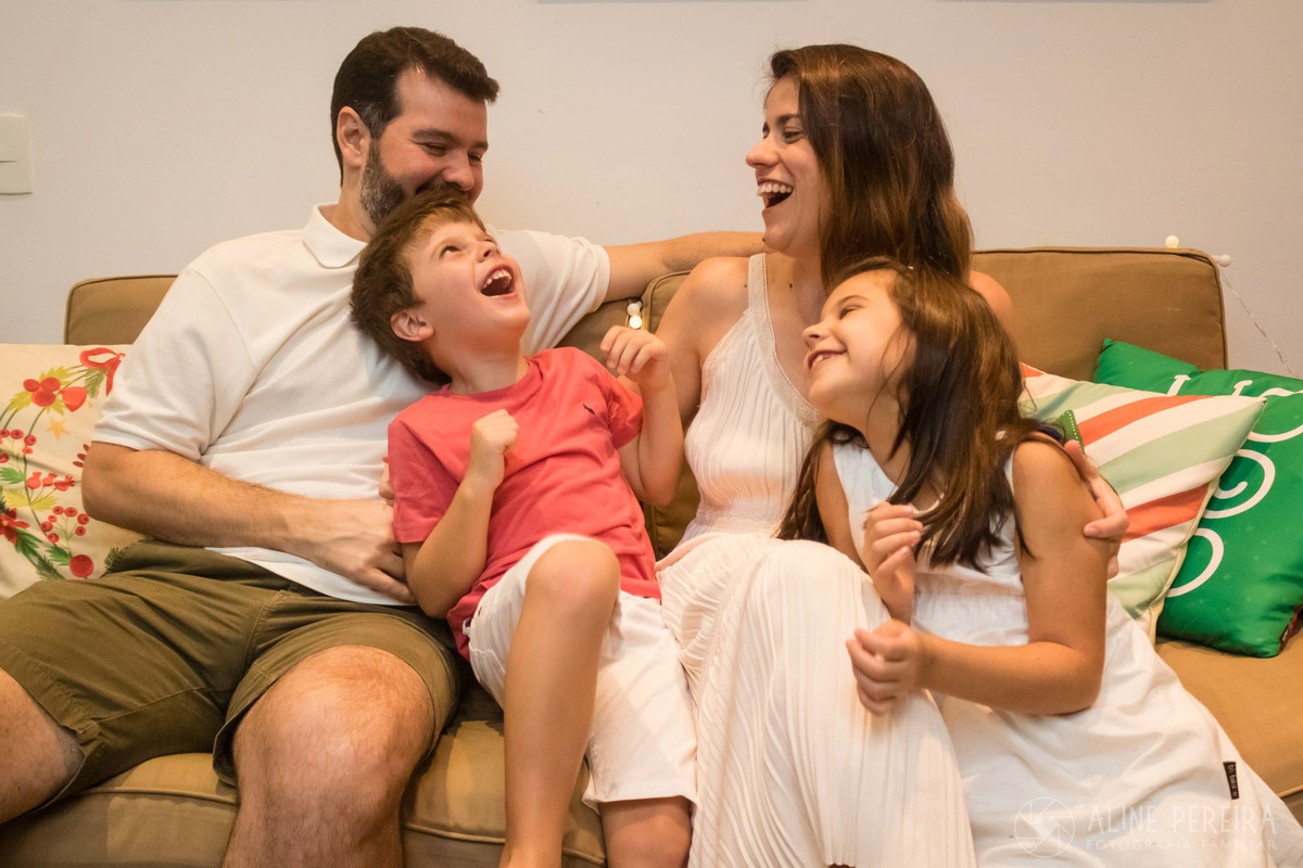 família sentada no sofa se divertindo 