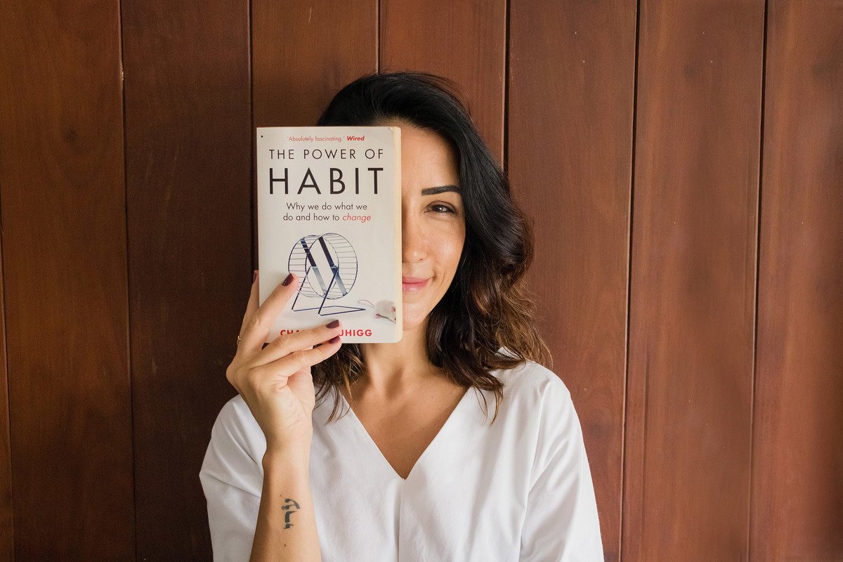 mulher segurando o livro o poder do hábito
