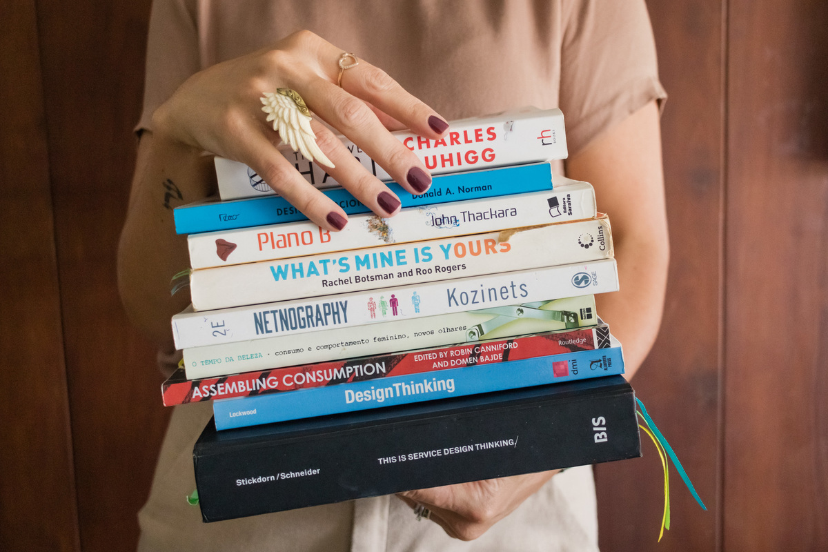 mulher estilosa segurando vários livros