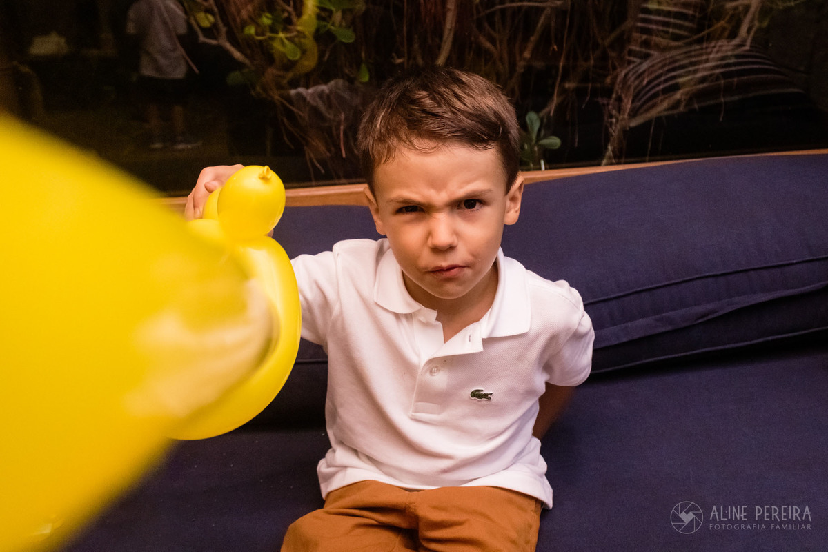 menino brincando com espada de bexiga