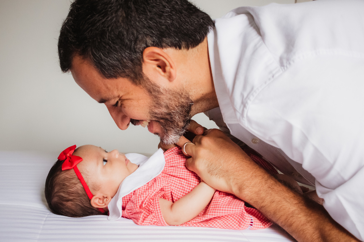 bebê deitada na capa e olhando para o pai