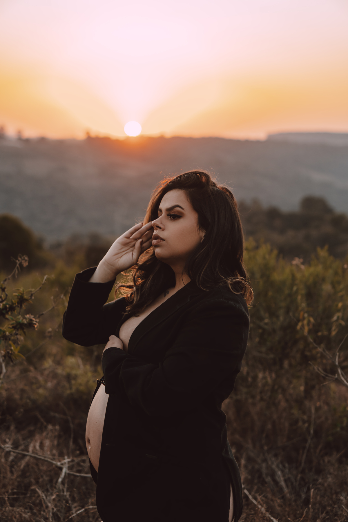 Ensaio de gestante no pôr do sol feito apenas com um blazer