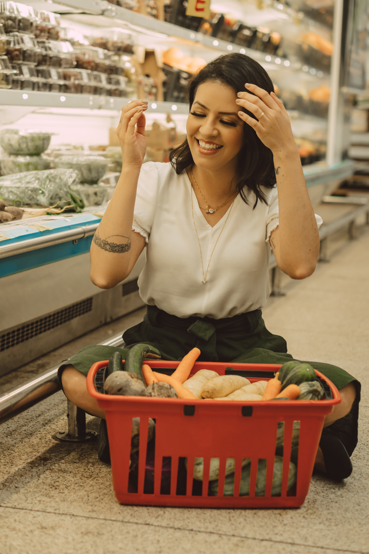 Ensaio corporativo de uma nutricionista feito em um mercado na sessão de verduras