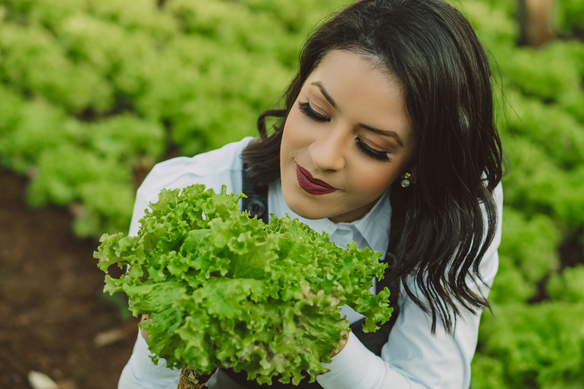 Ensaio corporativo nutricionista feito em uma chácara com alfaces