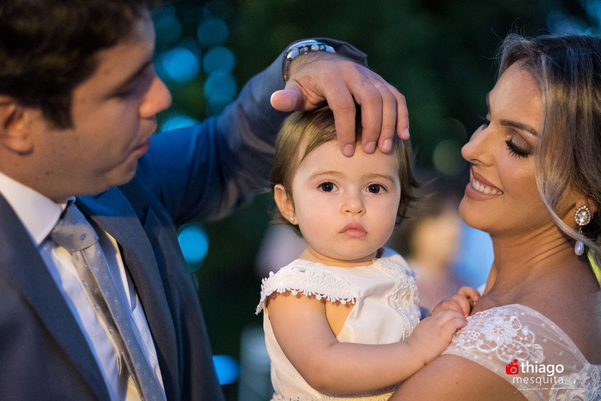 filha no colo dos pais se casando