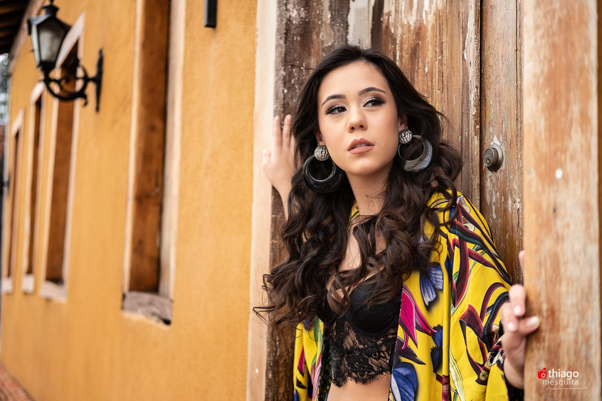 Book 15 anos da Elisa Bastos na frente do Alfaiateria